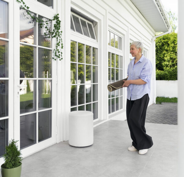 full-shot-woman-decorating-front-door-outside